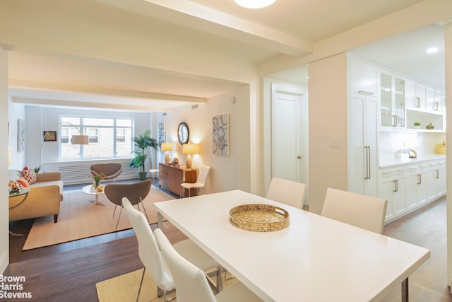 dining space featuring beam ceiling and dark hardwood / wood-style flooring