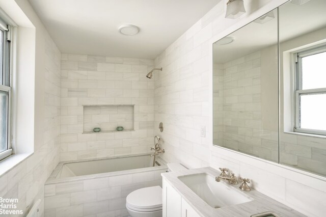 bathroom with toilet, tile walls, bathtub / shower combination, and vanity