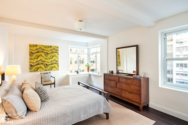 bedroom with beamed ceiling, multiple windows, wood finished floors, and baseboards