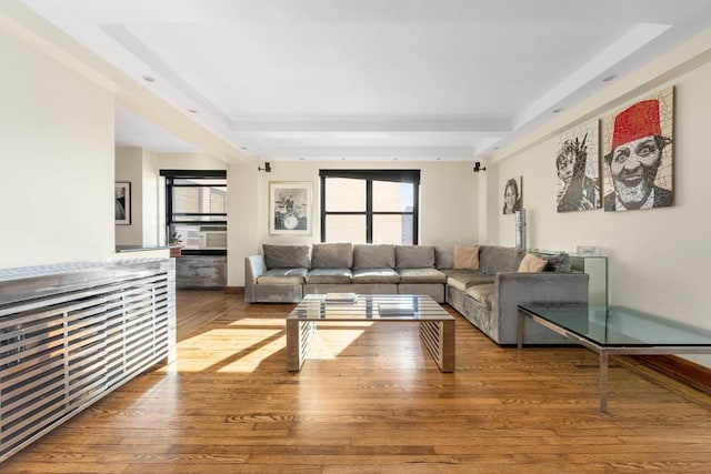 living room featuring beamed ceiling, cooling unit, and wood finished floors