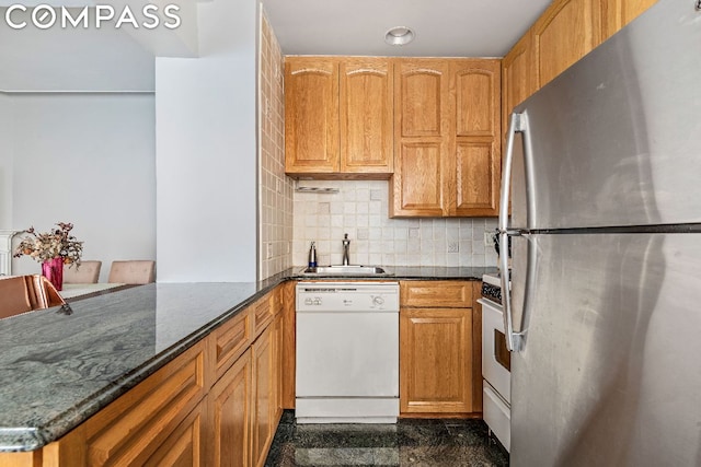 kitchen featuring sink, white appliances, kitchen peninsula, and tasteful backsplash