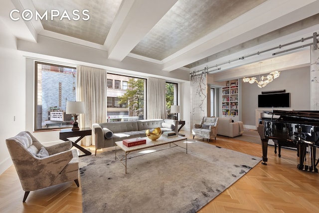 living area with baseboards, beam ceiling, a chandelier, and a barn door