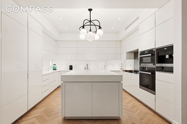 kitchen featuring modern cabinets, a chandelier, a kitchen island, white cabinetry, and recessed lighting