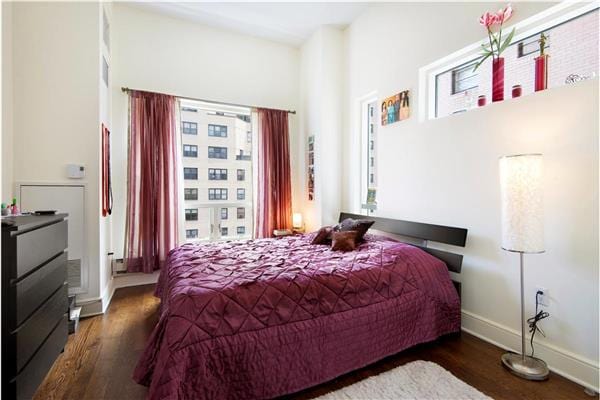 bedroom featuring dark wood finished floors and baseboards