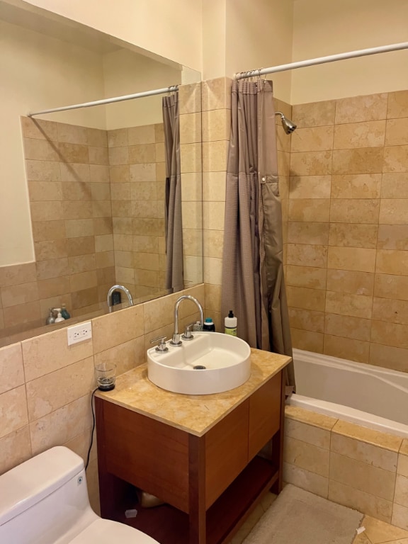 full bathroom with tiled shower / bath combo, vanity, and toilet