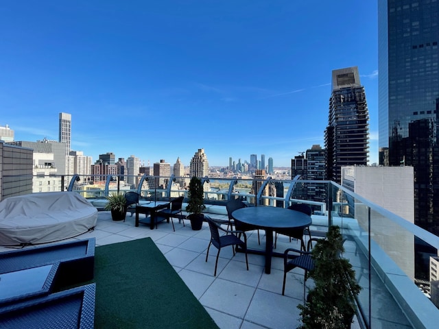 view of patio / terrace featuring a city view, a balcony, and a grill