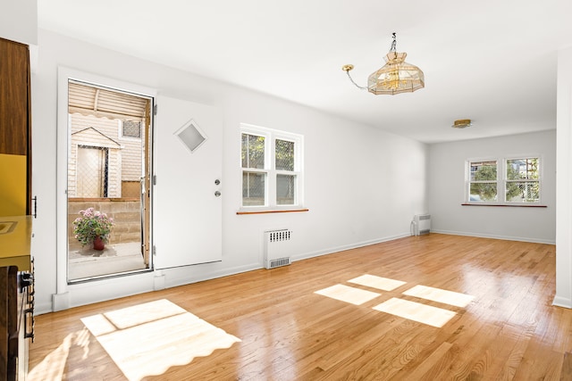 entryway with radiator, light wood-style flooring, and baseboards