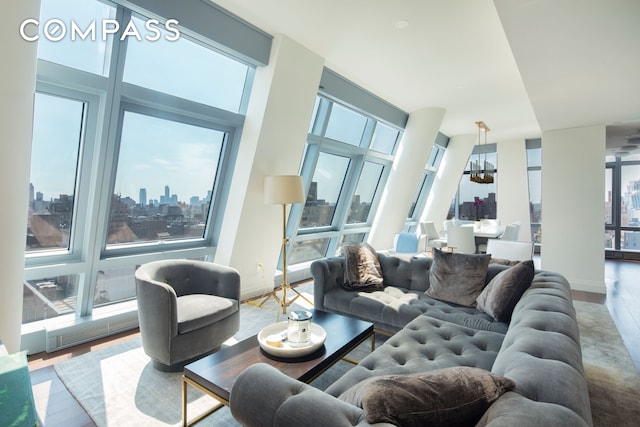 living room with a city view, wood finished floors, and a chandelier