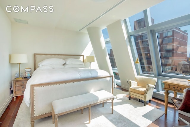 bedroom featuring baseboards, multiple windows, and wood finished floors