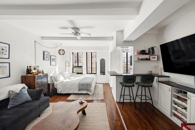 bedroom featuring dark wood-type flooring, beam ceiling, and ceiling fan