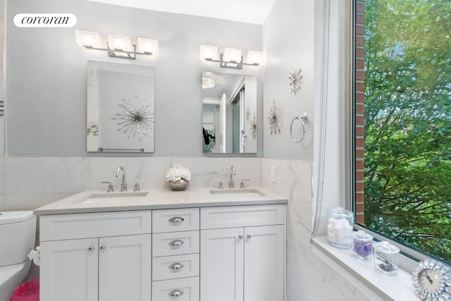 bathroom with vanity and tile walls