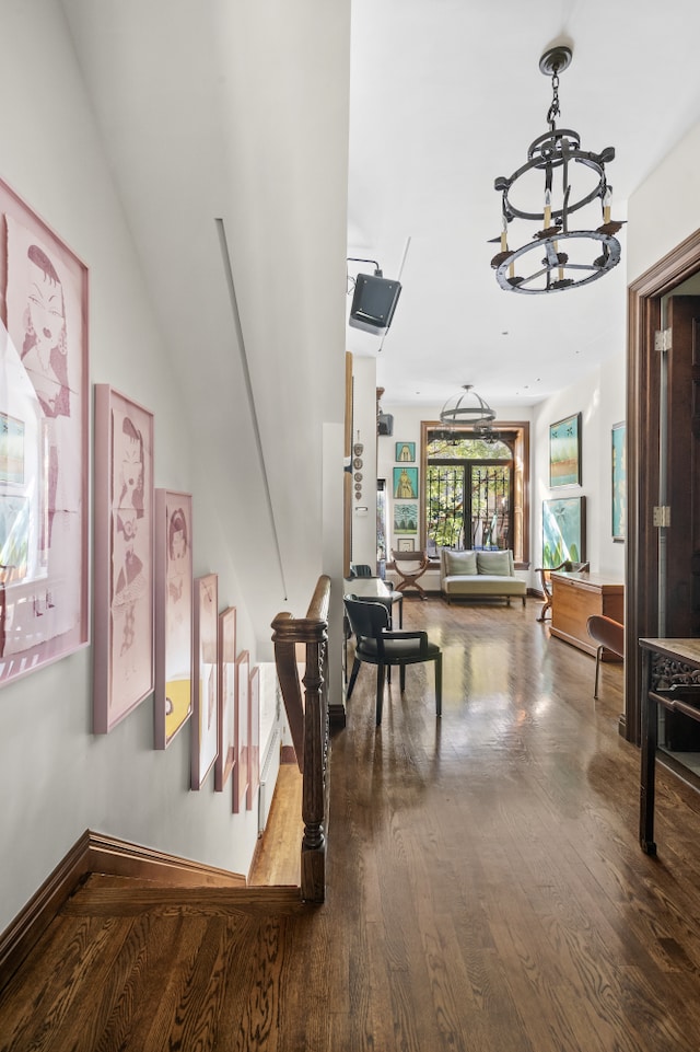 corridor with a chandelier and wood finished floors