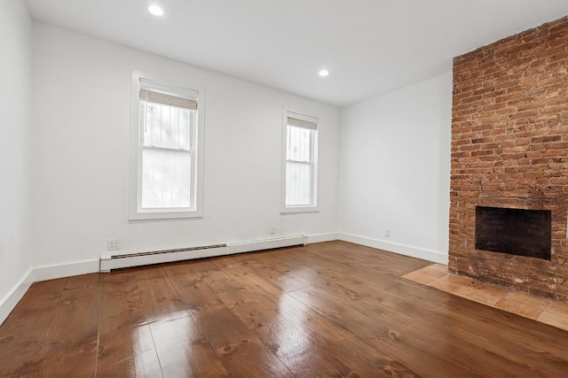 unfurnished living room featuring a brick fireplace, a baseboard radiator, baseboards, and wood finished floors