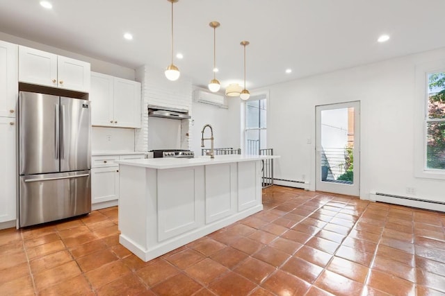 kitchen featuring light countertops, white cabinetry, freestanding refrigerator, and decorative light fixtures