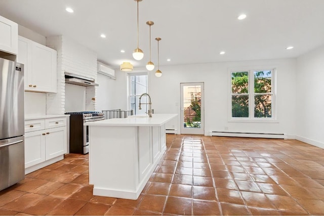 kitchen with a center island with sink, a baseboard radiator, appliances with stainless steel finishes, light countertops, and pendant lighting