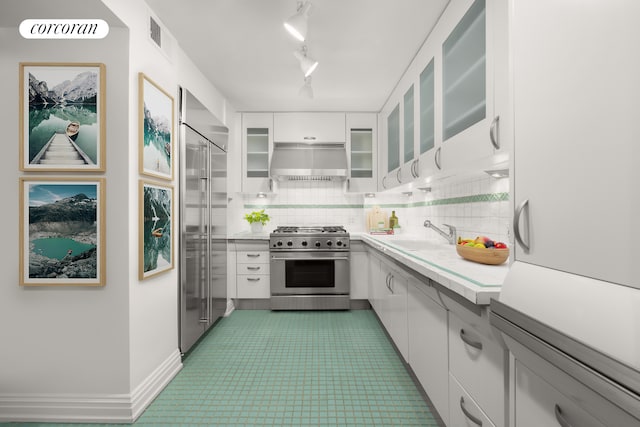27 E 65th St Unit 5Bc, New York City, NY 10065 - kitchen featuring high quality appliances, ventilation hood, light countertops, backsplash, and white cabinets