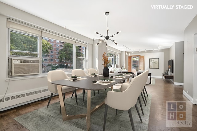 dining room featuring track lighting, a chandelier, cooling unit, baseboard heating, and baseboards