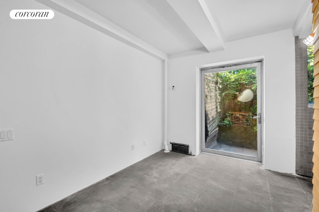 unfurnished room with beam ceiling