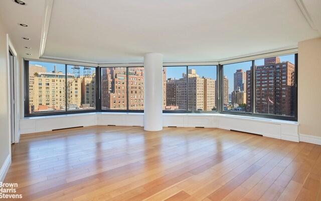 empty room with a city view, recessed lighting, and wood finished floors