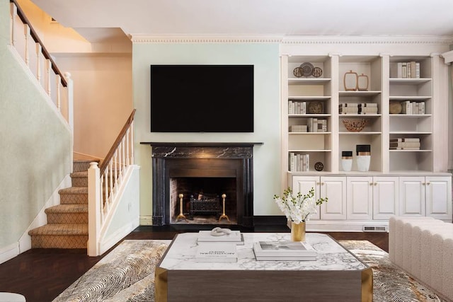 living room with a high end fireplace, crown molding, and dark hardwood / wood-style floors