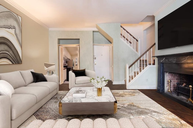 living room featuring dark wood-type flooring, ornamental molding, and a fireplace