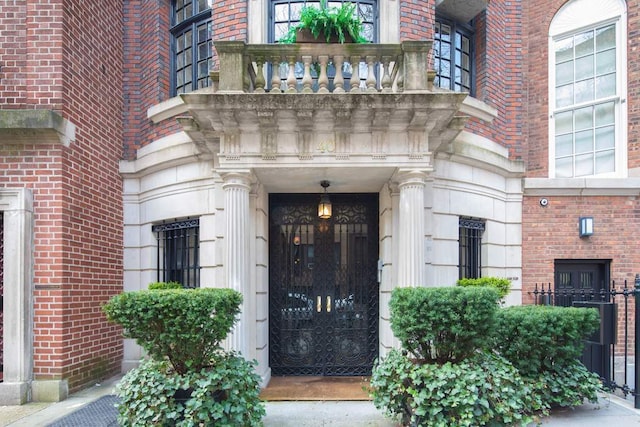 view of exterior entry with a balcony