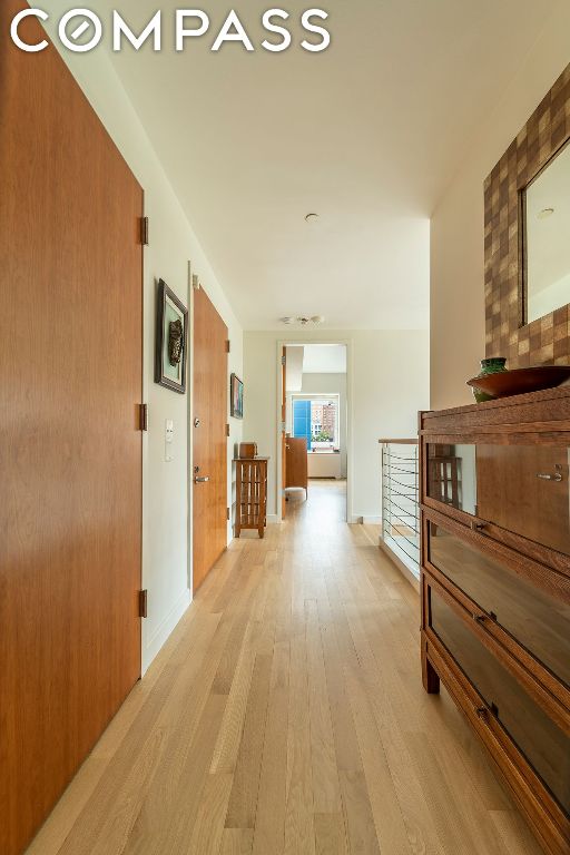 corridor with light hardwood / wood-style floors