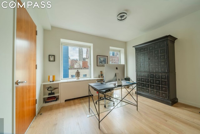 home office with light hardwood / wood-style floors