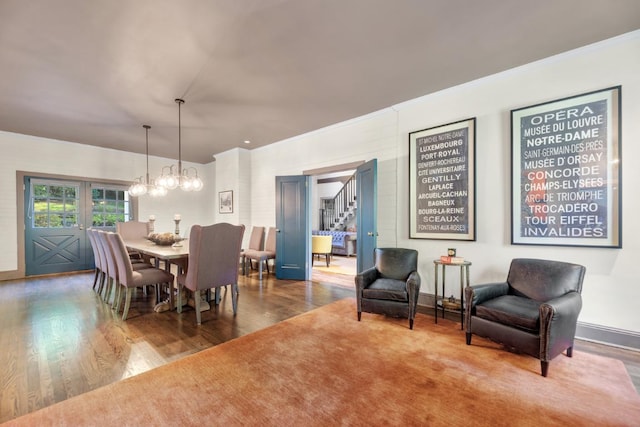 dining area featuring hardwood / wood-style floors, an inviting chandelier, and ornamental molding