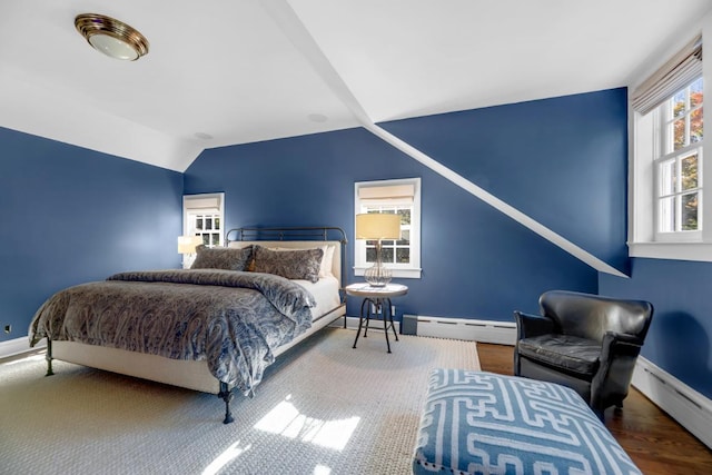 bedroom featuring vaulted ceiling, hardwood / wood-style flooring, and a baseboard radiator