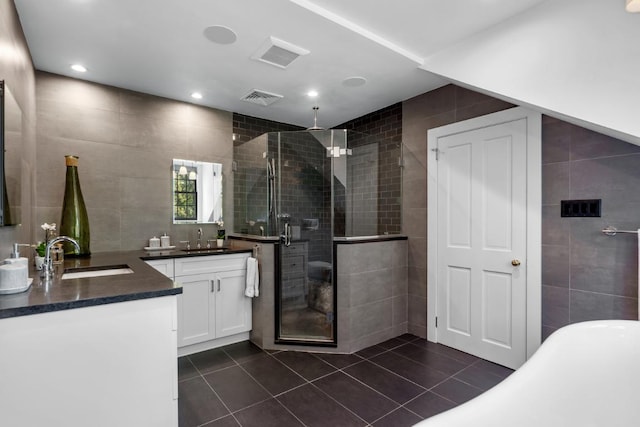 bathroom featuring tile walls, tile patterned flooring, independent shower and bath, and vanity