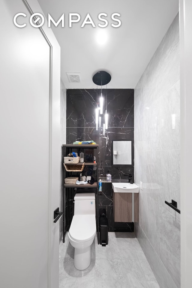 394 Harman St Unit 1B, New York City, NY 11237 - bathroom featuring tile walls, vanity, toilet, and marble finish flooring