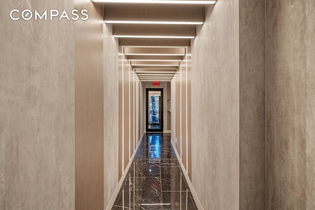 corridor featuring marble finish floor and baseboards