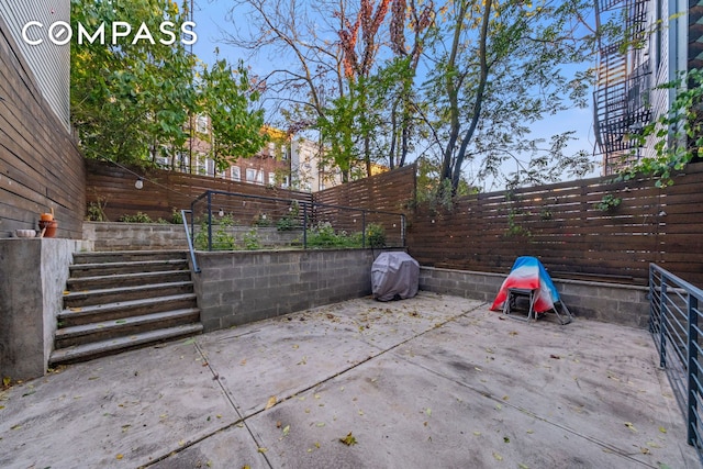 view of patio with a fenced backyard and stairway