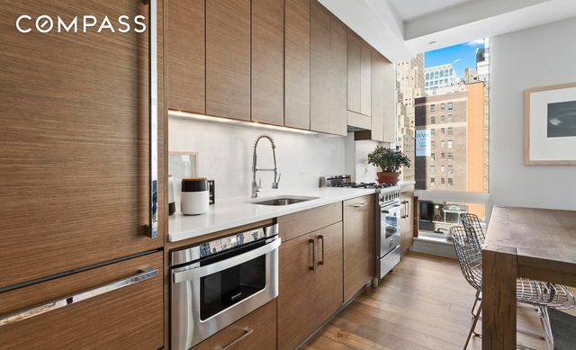325 Lexington Ave Unit 10D, New York City, NY 10016 - kitchen featuring stainless steel appliances, wood finished floors, light countertops, modern cabinets, and a view of city