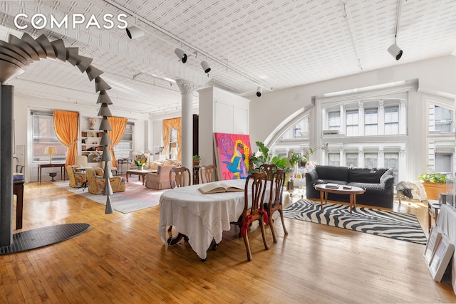 dining room featuring track lighting, wood-type flooring, and healthy amount of natural light