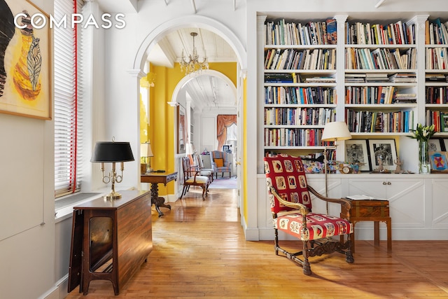 living area featuring arched walkways and wood-type flooring
