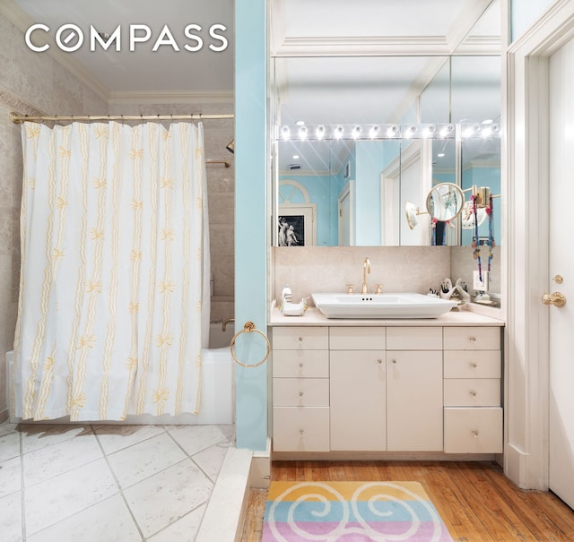 full bathroom with shower / bathtub combination with curtain, vanity, ornamental molding, and wood finished floors