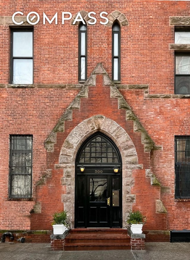 view of exterior entry with brick siding