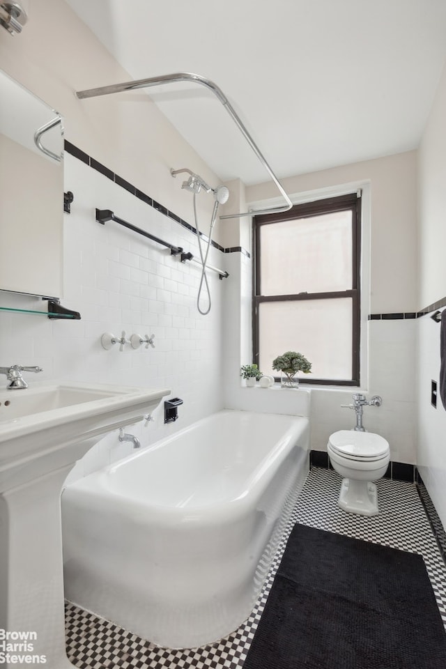 bathroom featuring tile patterned floors, toilet, tile walls, and shower / washtub combination