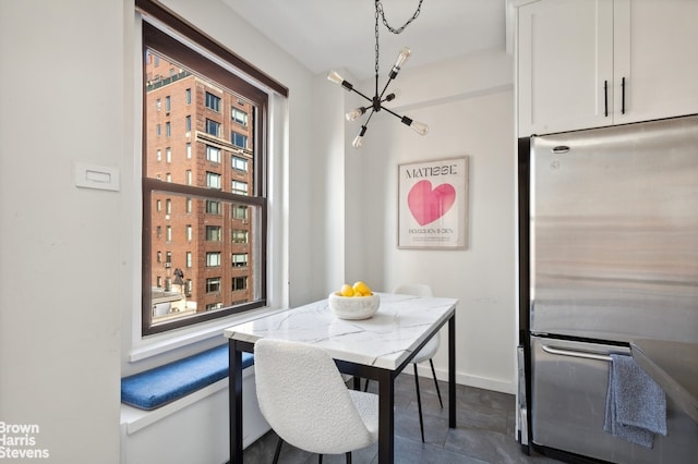 dining area featuring a chandelier and baseboards