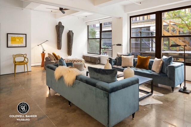 living area featuring radiator, finished concrete flooring, and ceiling fan