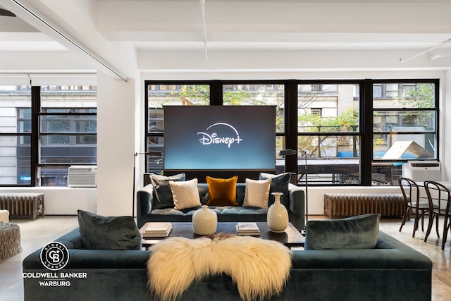 living area featuring radiator heating unit, plenty of natural light, and cooling unit