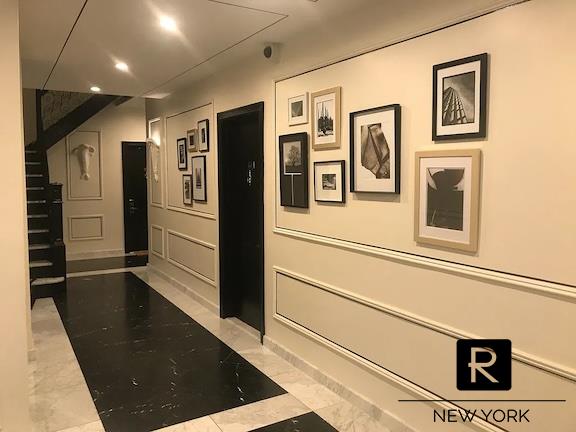 hallway with marble finish floor, stairway, a decorative wall, and recessed lighting