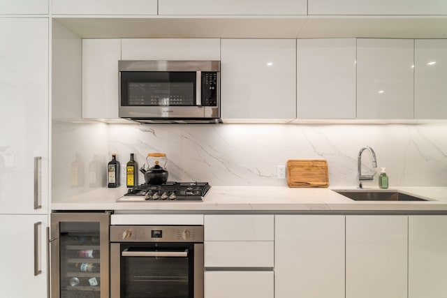 kitchen with stainless steel appliances, white cabinetry, and wine cooler