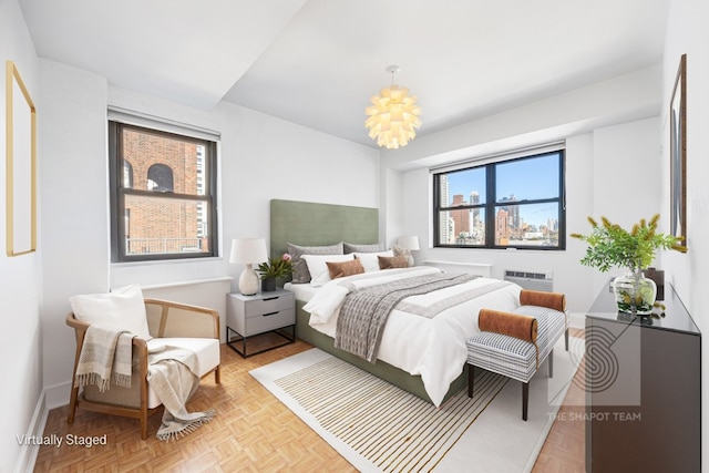 bedroom featuring light parquet flooring, multiple windows, and a wall mounted AC