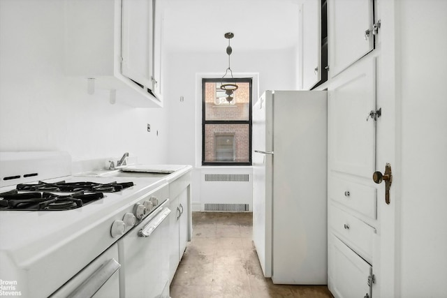 kitchen with white fridge, decorative light fixtures, radiator, white cabinets, and sink