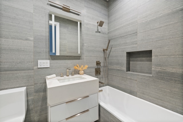 bathroom featuring tiled shower / bath and vanity