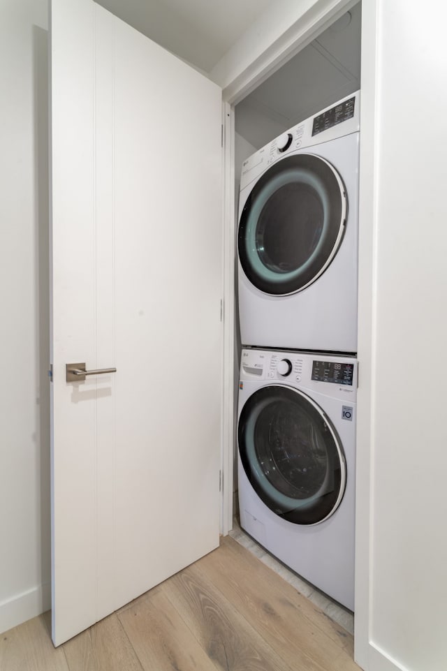 249 E 50th St Unit 7A, New York City, NY 10022 - laundry room with stacked washer / dryer and light wood-style floors