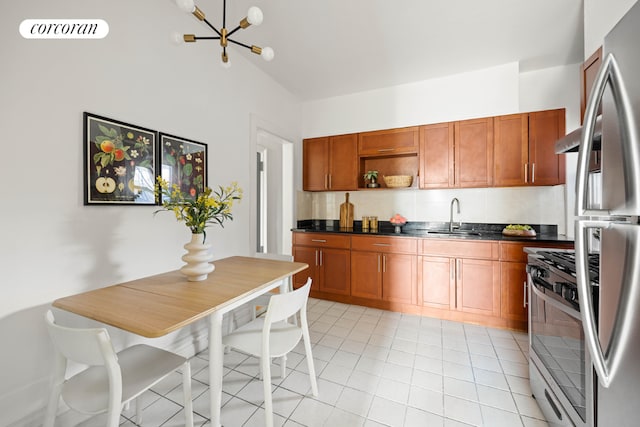 kitchen with light tile patterned flooring, appliances with stainless steel finishes, sink, and a notable chandelier